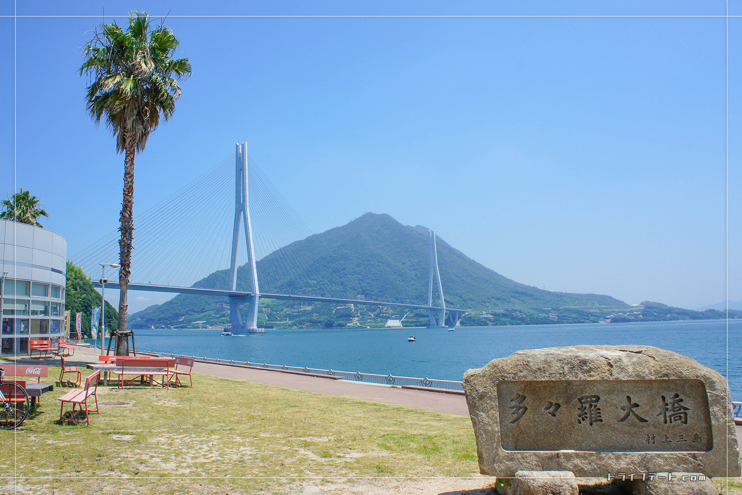 多々羅大橋と書かれた石碑とともに見えてくる多々羅大橋と、海を挟んで見える生口島